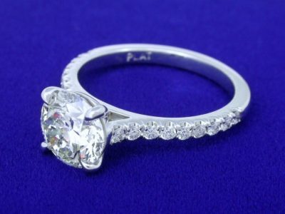 Custom platinum mounting with four-prong modified basket-style head and 18 French V split pave-set round diamonds